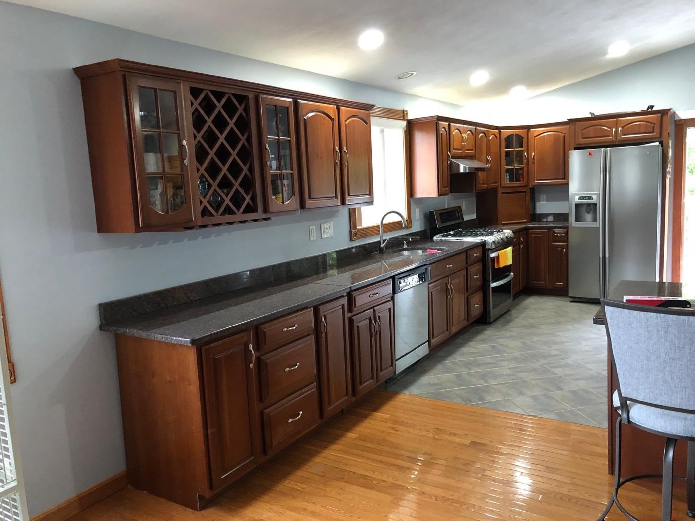 Kitchen with dark wood cabinets before refinishing